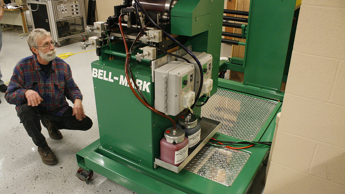 Print technician inspecting flexographic printer